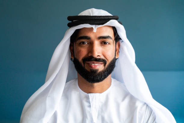 Arab man wearing traditional emirate clothing  working in the office - Middle eastern businessman portrait